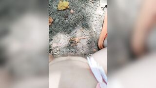 Girl pisses in wood on dry ground