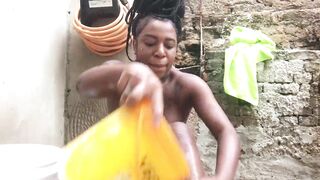 Black woman from Bahia bathing in a bucket in the backyard.